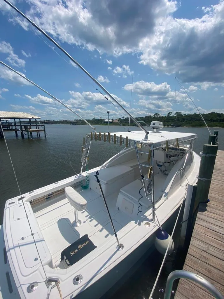 Slide: The Image of 1970 Bertram 31 Bahia Mar boat docked under a partly cloudy sky. - 10