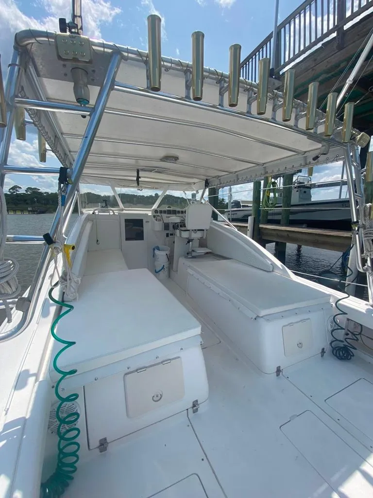 Slide: The Image of 1970 Bertram 31 Bahia Mar boat with spacious deck and canopy, docked at marina. - 12