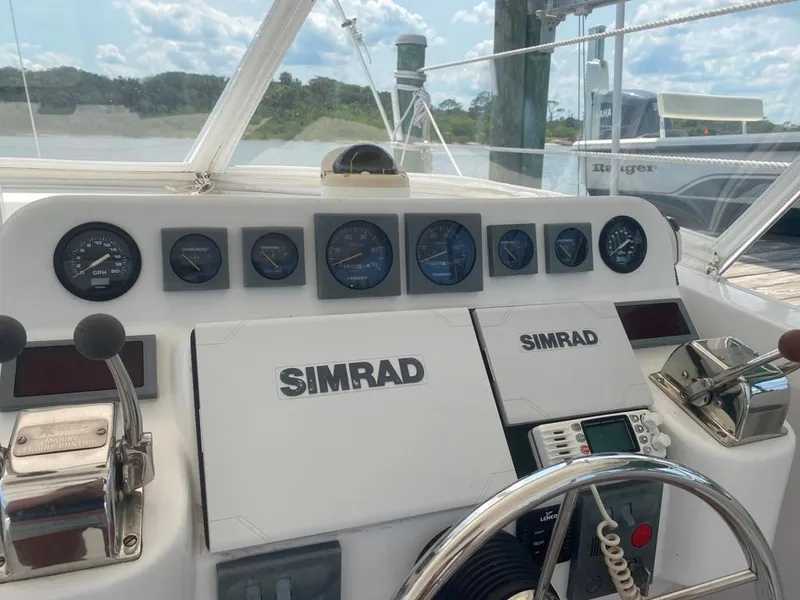 Slide: The Image of 1970 Bertram 31 Bahia Mar boat dashboard with Simrad navigation equipment and gauges. - 15