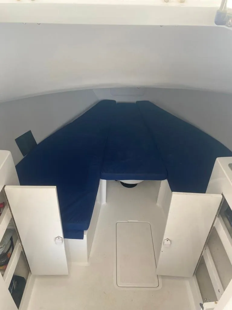 Slide: The Image of 1970 Bertram 31 Bahia Mar cabin interior with blue cushions and white storage compartments. - 17