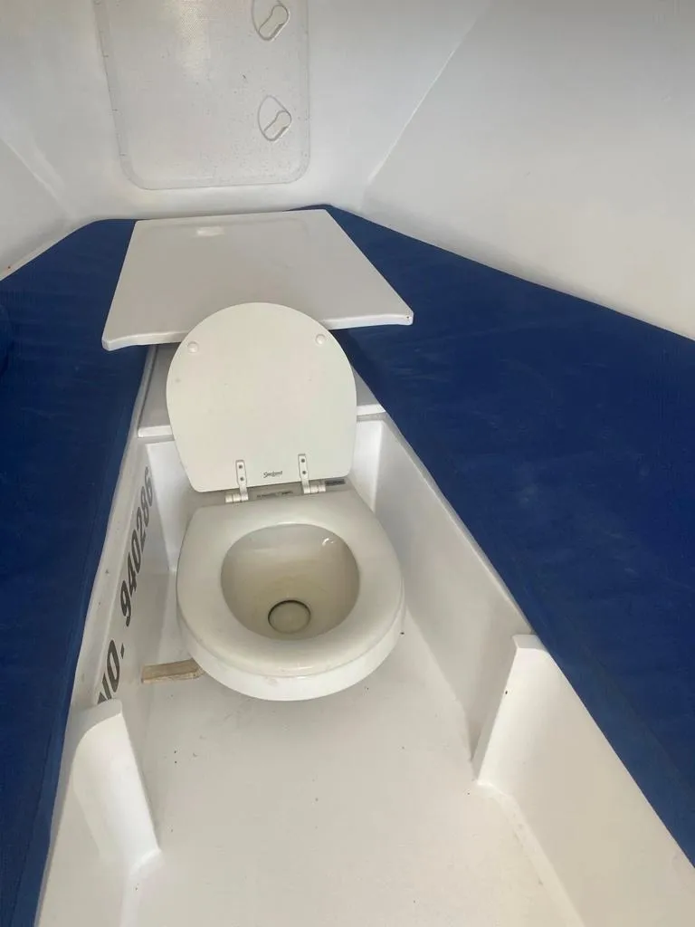Slide: The Image of 1970 Bertram 31 Bahia Mar boat interior with toilet and blue seating. - 18