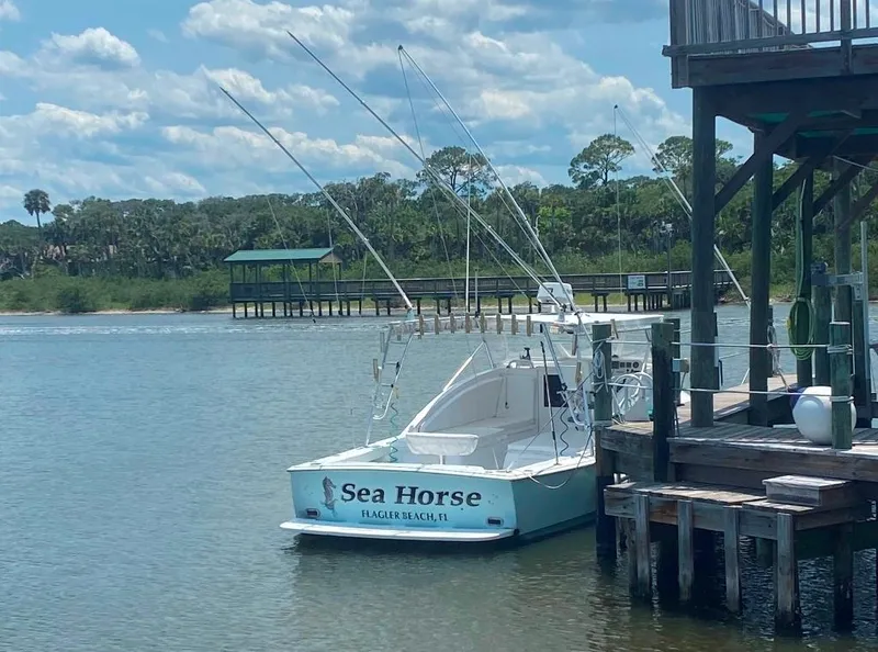 Slide: The Image of 1970 Bertram 31 Bahia Mar boat named "Sea Horse" docked by a wooden pier. - 3