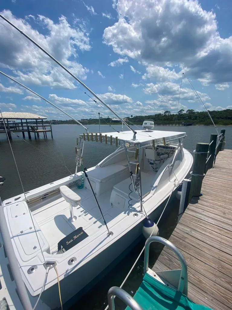 Slide: The Image of 1970 Bertram 31 Bahia Mar boat docked under a partly cloudy sky. - 5