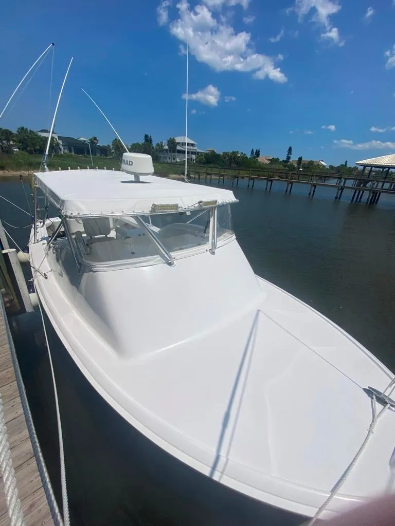 Slide: The Image of 1970 Bertram 31 Bahia Mar boat docked under a clear blue sky. - 7