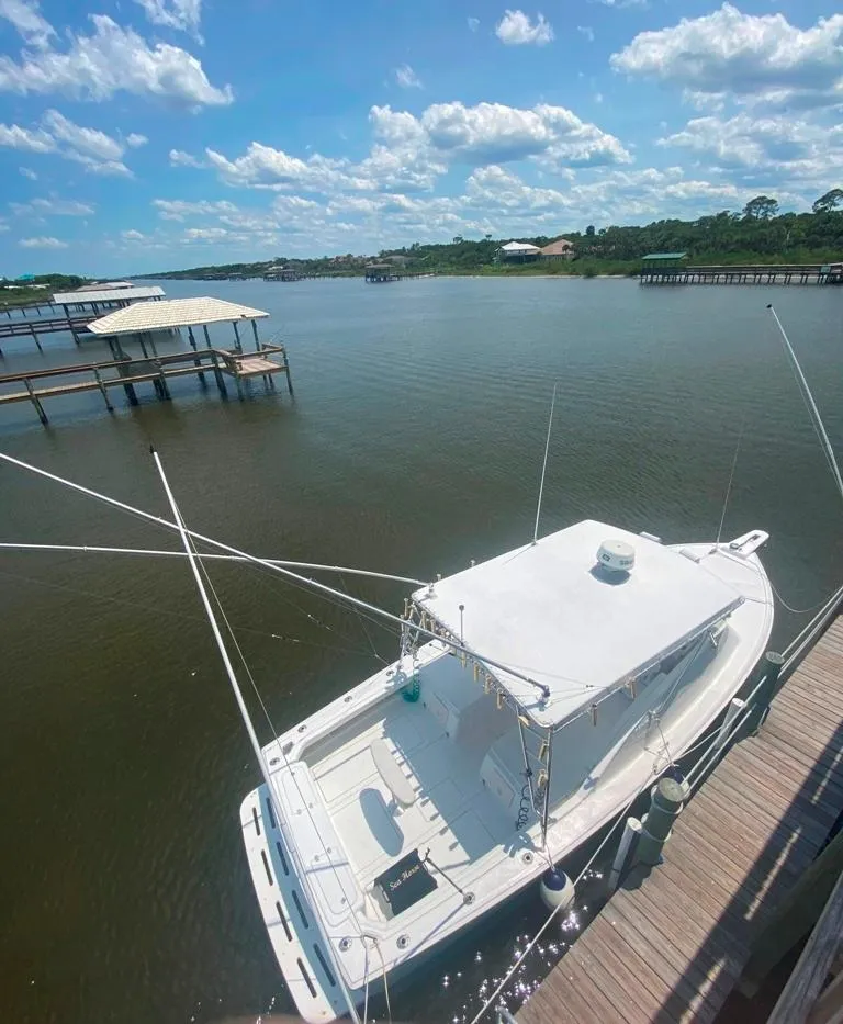 Slide: The Image of 1970 Bertram 31 Bahia Mar docked on a sunny day with blue skies and calm waters. - 9