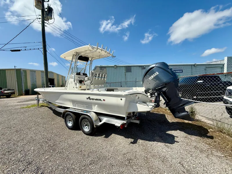 Slide: The Image of 2025 Avenger AV26 boat with Yamaha engine on a trailer, parked outdoors. - 2