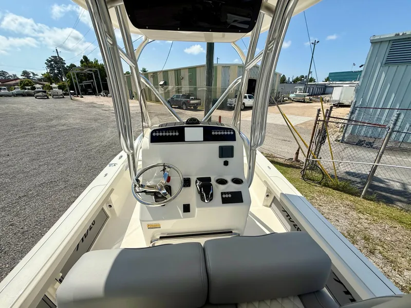 Slide: The Image of 2025 Avenger AV26 boat cockpit with steering wheel and control panel, parked outdoors. - 6