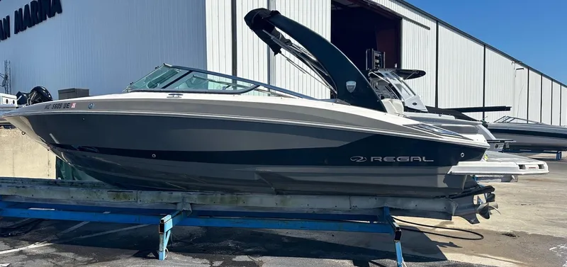 The Image of 2018 Regal 2500 Bowrider boat on a trailer outside a marina. - 1
