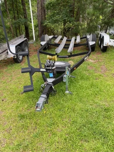 Slide: The Image of 2016 Triton 179 TrX boat trailer on grass, surrounded by trees. - 11