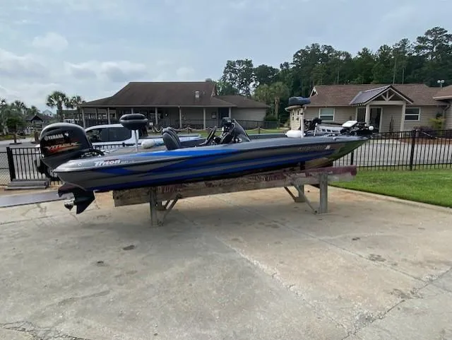 Slide: The Image of 2016 Triton 179 TrX boat on a trailer, parked in a residential driveway. - 2