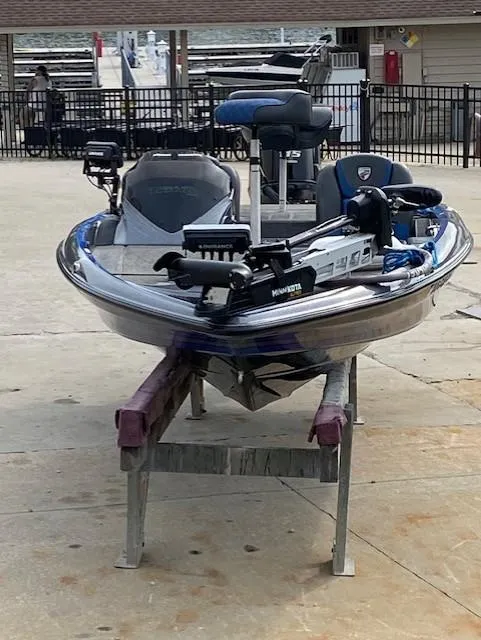 Slide: The Image of 2016 Triton 179 TrX bass boat on a stand, equipped with a Minn Kota trolling motor. - 4