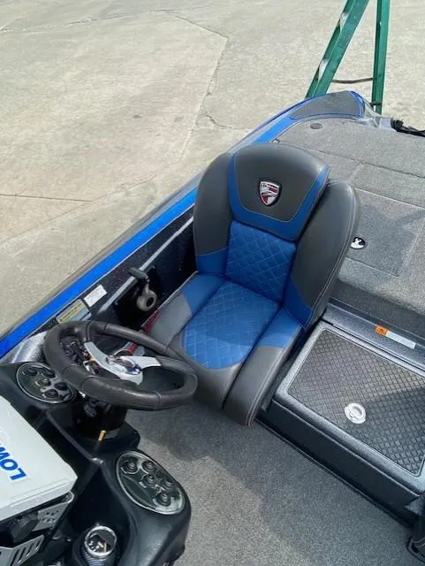 Slide: The Image of 2016 Triton 179 TrX boat interior with blue and gray seating and steering console. - 6