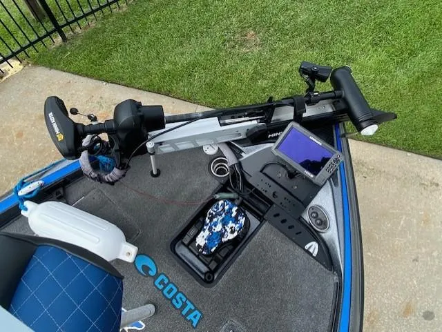 Slide: The Image of 2016 Triton 179 TrX boat deck with trolling motor and fish finder, on grass and concrete. - 9