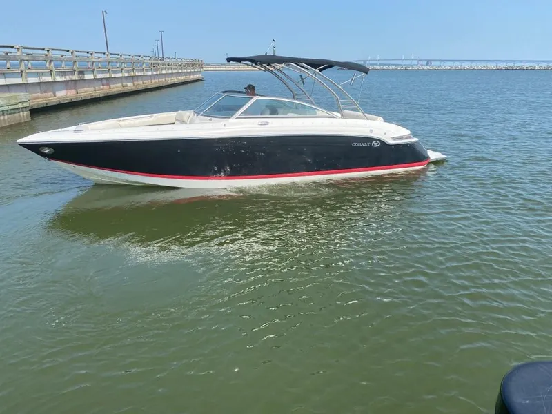 The Image of 2014 Cobalt 276 boat cruising on calm water near a pier. - 1