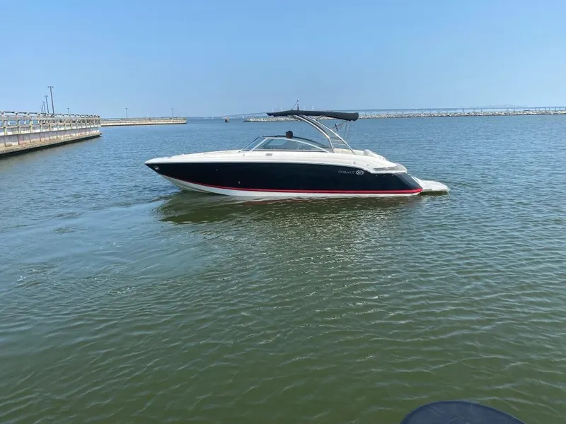 Slide: The Image of 2014 Cobalt 276 boat cruising on a calm lake under a clear blue sky. - 4