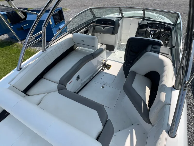 Slide: The Image of 2014 Cobalt 276 boat interior with white and gray seating, steering wheel, and open deck layout. - 9