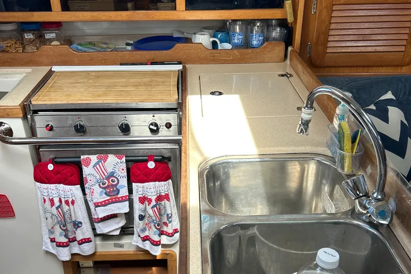 Slide: The Image of Galley kitchen in 1998 Catalina 36MKII sailboat with stove, sink, and colorful towels. - 22