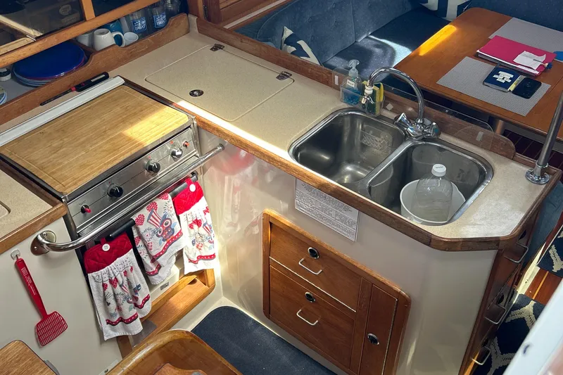 Slide: The Image of 1998 Catalina 36MKII yacht kitchen with stove, sink, and wooden cabinetry. - 23