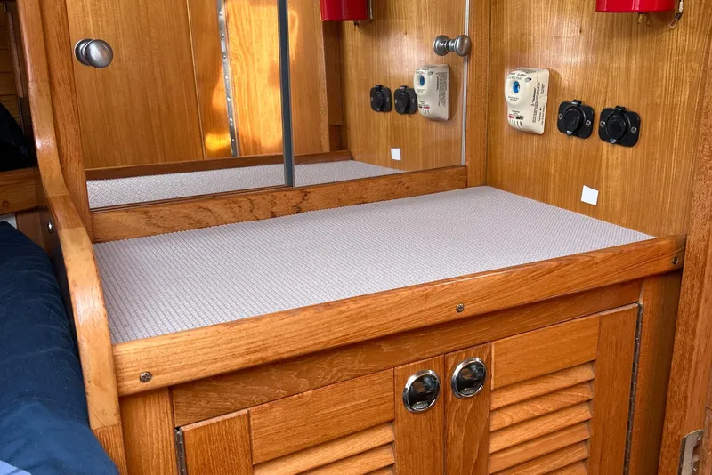 Slide: The Image of Wooden interior of a 1998 Catalina 36MKII sailboat with storage and control panels. - 28
