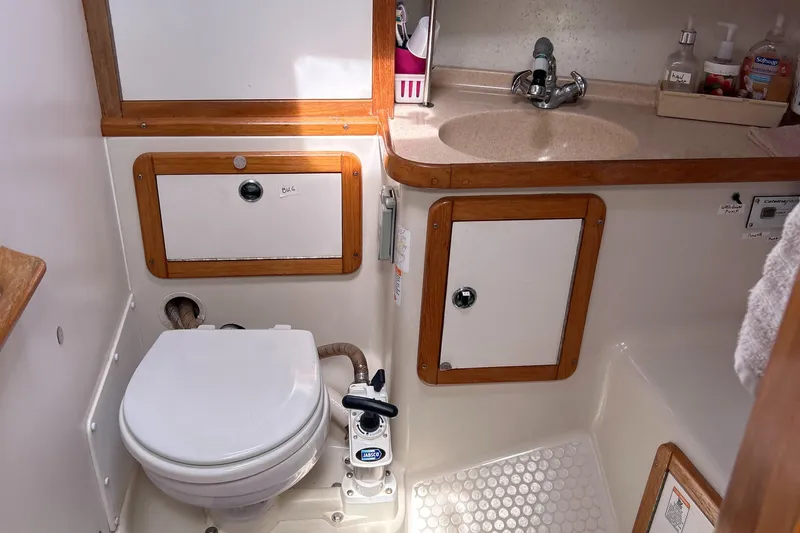 Slide: The Image of 1998 Catalina 36MKII boat bathroom with toilet, sink, and storage cabinets. - 29