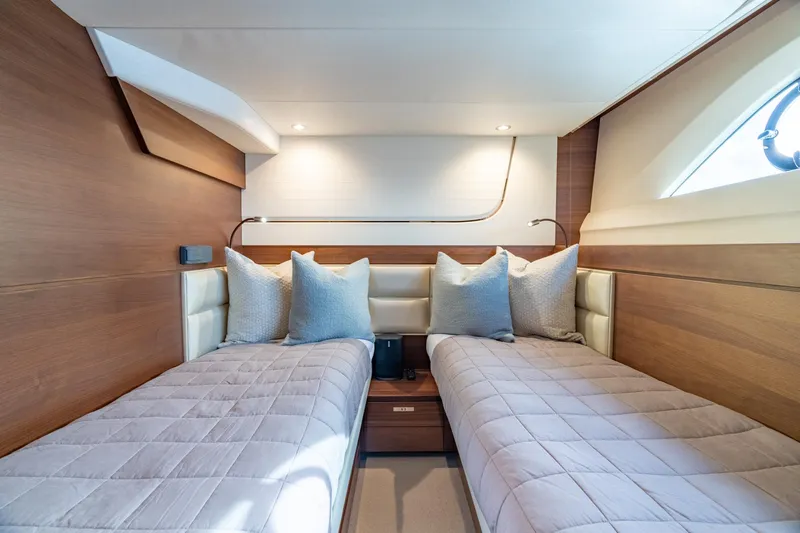 Slide: The Image of Luxurious twin cabin interior on 2019 Princess F70 yacht, featuring elegant wood paneling and plush bedding. - 12