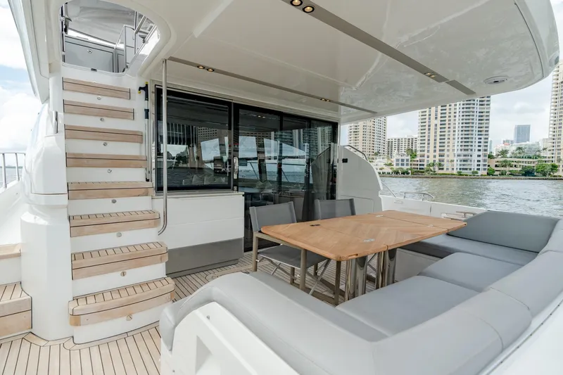 Slide: The Image of Luxurious 2019 Princess F70 yacht deck with seating, table, and staircase, overlooking waterfront cityscape. - 19