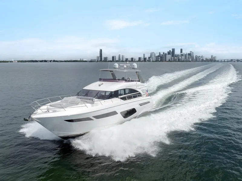 Slide: The Image of 2019 Princess F70 yacht cruising on open water with city skyline in background. - 2