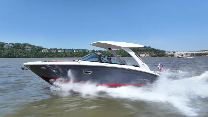 The Image of 2025 Regal LS9 boat speeding on a lake under clear blue skies. - 0
