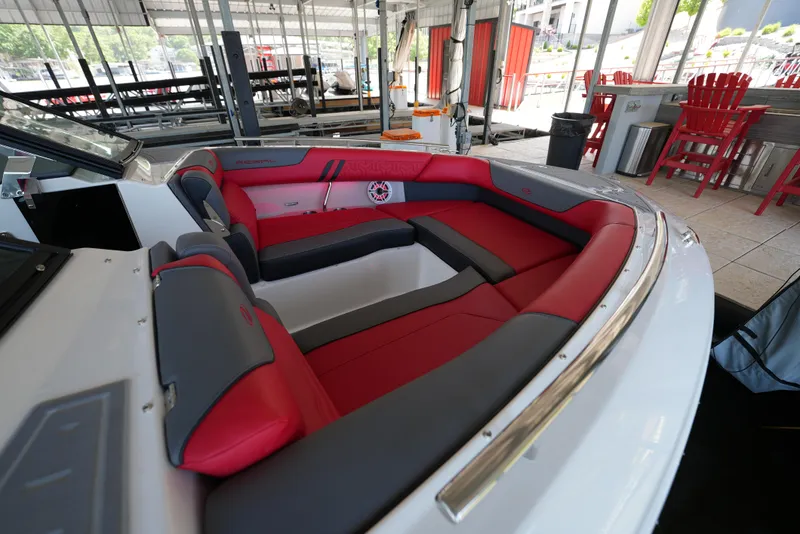 Slide: The Image of 2025 Regal LS9 boat interior with red and gray seating, docked under a canopy. - 10