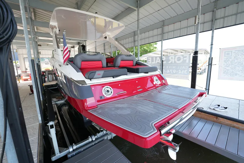 Slide: The Image of 2025 Regal LS9 boat in dock, featuring red and white design with American flag. - 15