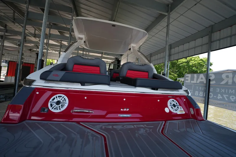 Slide: The Image of 2025 Regal LS9 boat with red and black seating, docked under a metal canopy. - 26