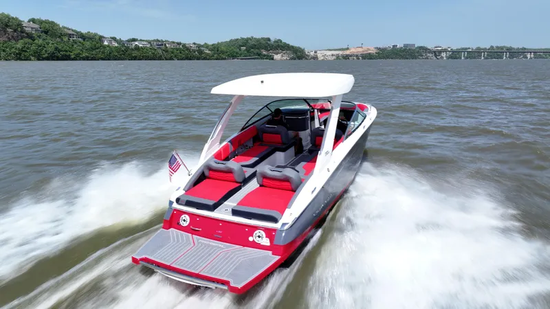 Slide: The Image of 2025 Regal LS9 boat cruising on a lake with red and gray seating. - 3