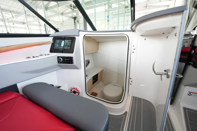 Slide: The Image of Interior of 2025 Regal LS9 boat featuring a compact bathroom and modern dashboard. - 35