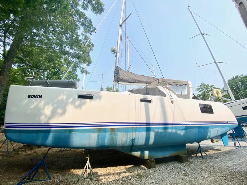 Slide: The Image of 2016 Celtic Yachts 40 sailboat on stands, white hull with blue stripe, outdoors. - 12