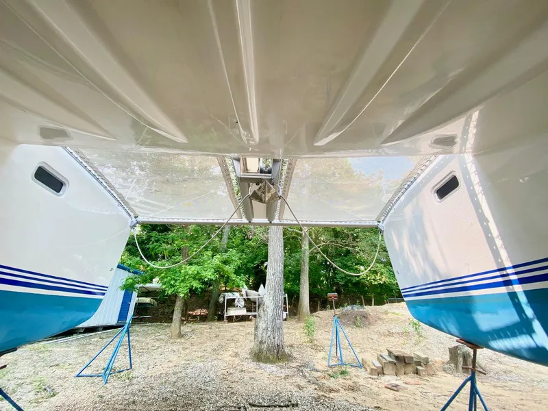 Slide: The Image of 2016 Celtic Yachts 40 catamaran on stands, viewed from below, with trees in the background. - 6