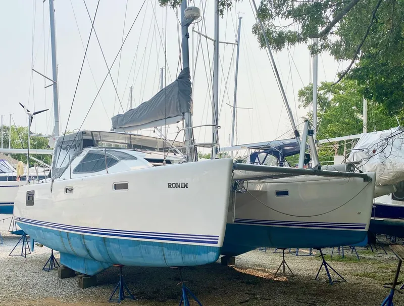 Slide: The Image of 2016 Celtic Yachts 40 catamaran on stands, white hull, blue accents, outdoor setting. - 10