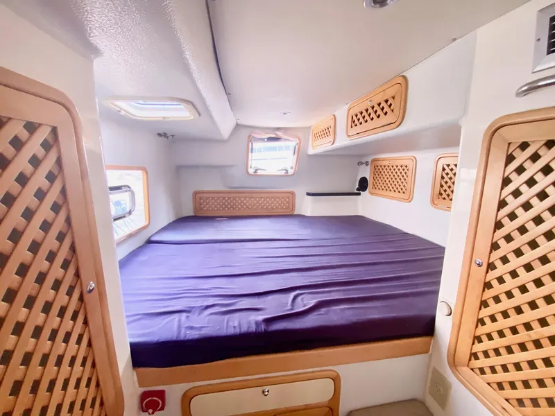 Slide: The Image of Cozy cabin interior of 2016 Celtic Yachts 40 with lattice wood accents and purple bedding. - 36