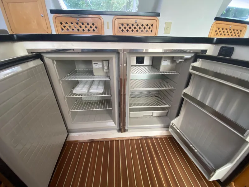 Slide: The Image of Open double-door fridge in 2016 Celtic Yachts 40, featuring spacious interior and wooden flooring. - 40