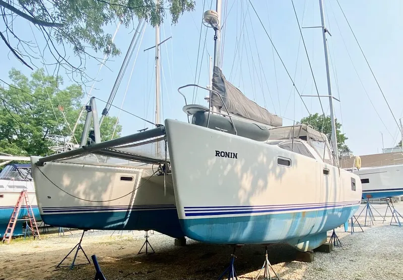 Slide: The Image of 2016 Celtic Yachts 40 catamaran on stands, named "Ronin," with blue and white hull. - 9