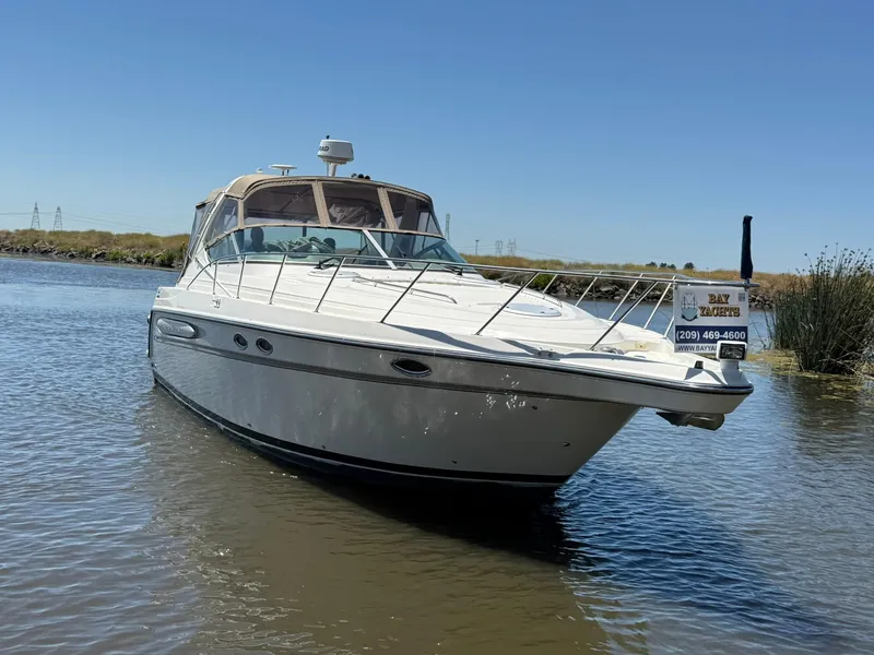 Slide: The Image of 2000 Maxum 3700 SCR yacht on calm water, clear sky, Bay Yachts sign visible. - 2