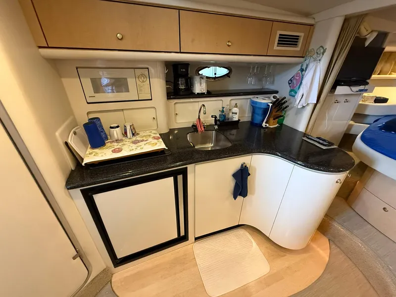 Slide: The Image of Compact kitchen area in a 2000 Maxum 3700 SCR yacht, featuring modern amenities and sleek design. - 33