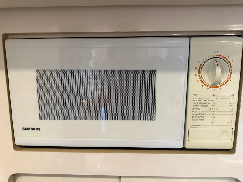 Slide: The Image of White Samsung microwave with manual dial timer, built into a kitchen cabinet. - 36