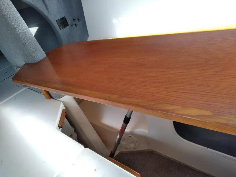 Slide: The Image of Interior of 2004 Corsair F-24MKII sailboat with wooden table and storage area. - 12