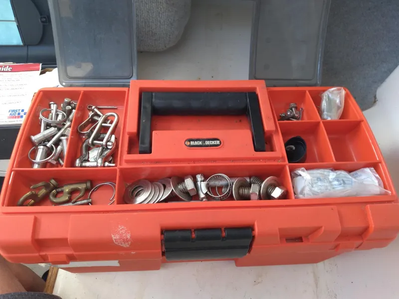 Slide: The Image of Red toolbox with assorted hardware, including bolts and washers, on a Corsair F-24MKII, 2004 model. - 15