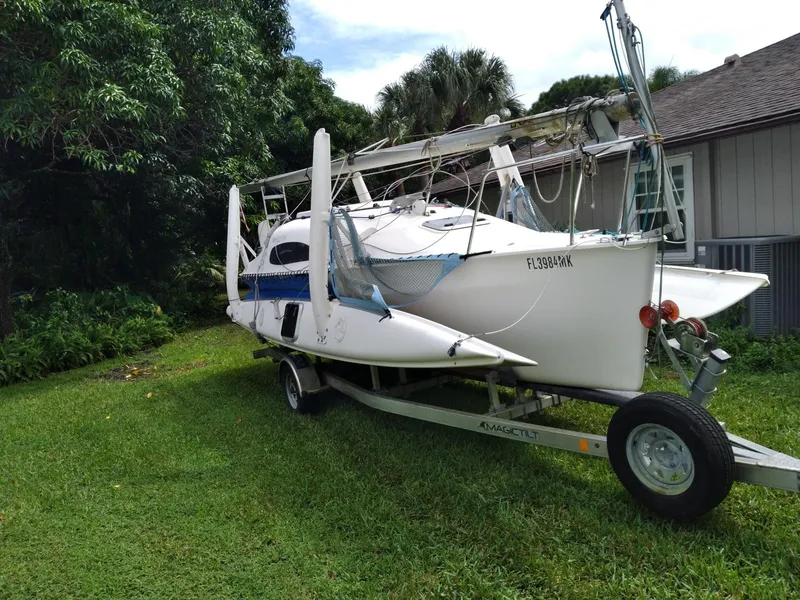 Slide: The Image of Corsair F-24MKII trimaran sailboat on trailer, parked on grass beside a house. - 7