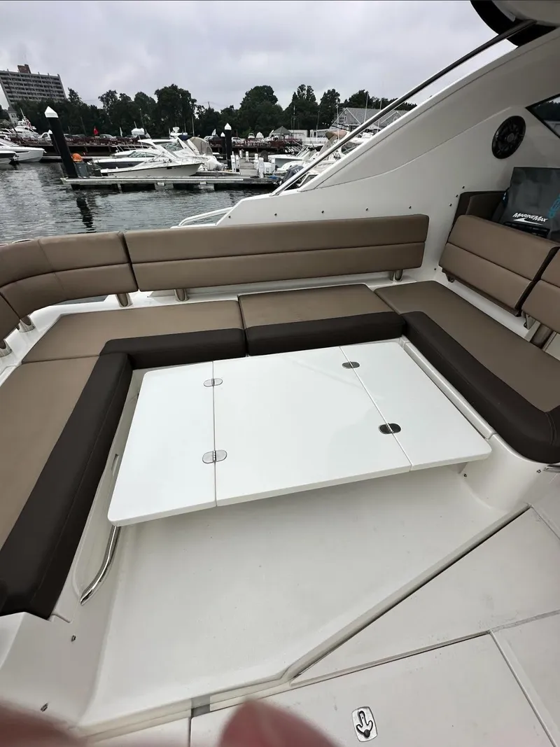 Slide: The Image of 2018 Galeon 385 HTS yacht with spacious seating and table, docked at a marina. - 10