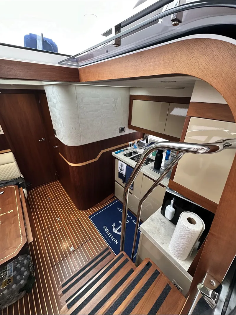 Slide: The Image of Interior of 2018 Galeon 385 HTS yacht with modern wood finishes and compact kitchen area. - 13
