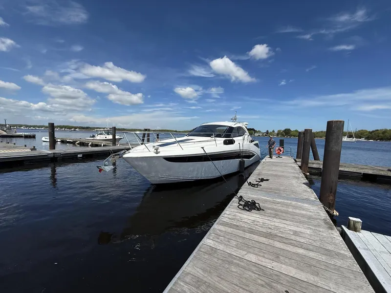 Slide: The Image of 2018 Galeon 385 HTS yacht docked at a marina under a clear blue sky. - 2