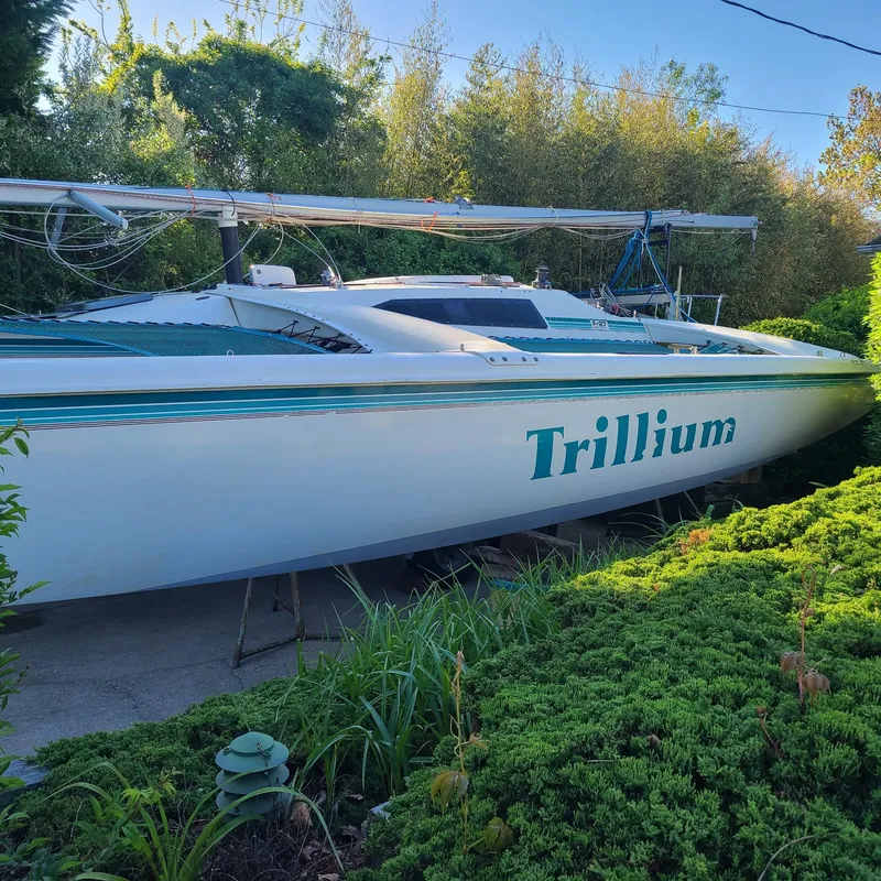 Slide: The Image of 1992 Corsair F-27 sailboat "Trillium" on land, surrounded by greenery. - 3