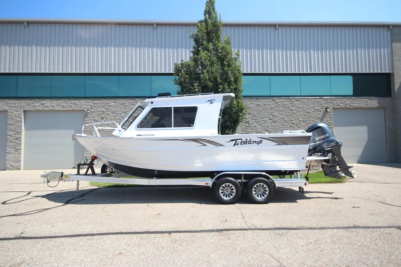 The Image of 2026 Weldcraft 220 Ocean King F250 boat on trailer, parked outside industrial building. - 1